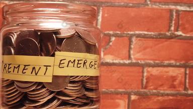 玻璃Jar完整的硬币钱砖背景驾驭揭示紧急房子储蓄退休单词金融投资储蓄概念
